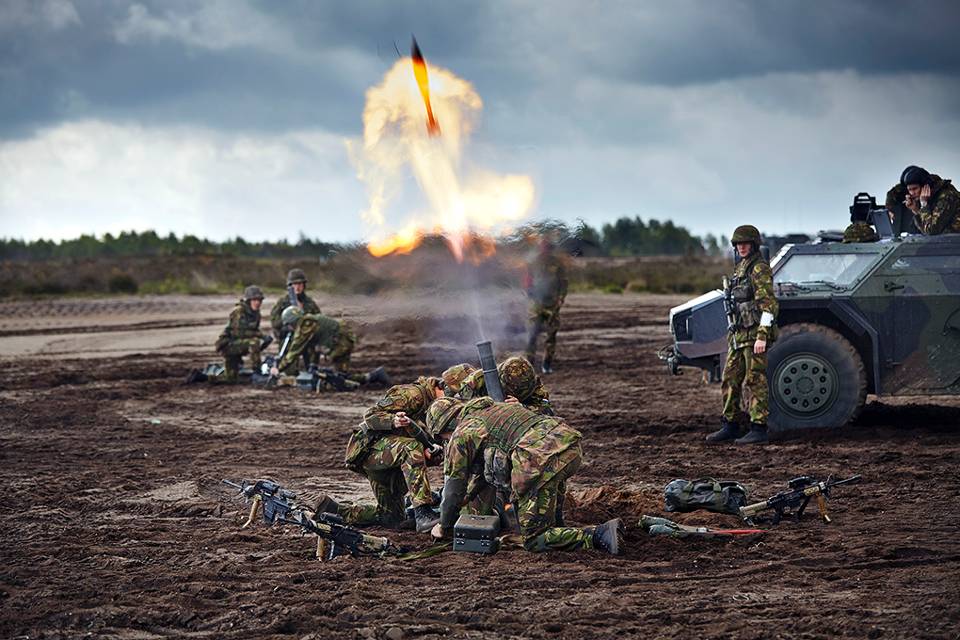 Militairen lanceren een mortier de lucht in.