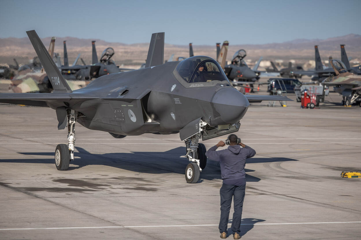 een crew chief ontvangt een F-35 die terug komt van een vlucht.