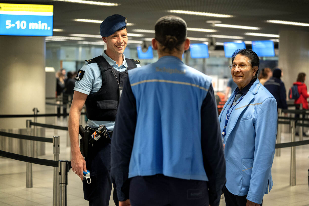 Brigadecommandant in gesprek met medewerkers van luchthaven Schiphol