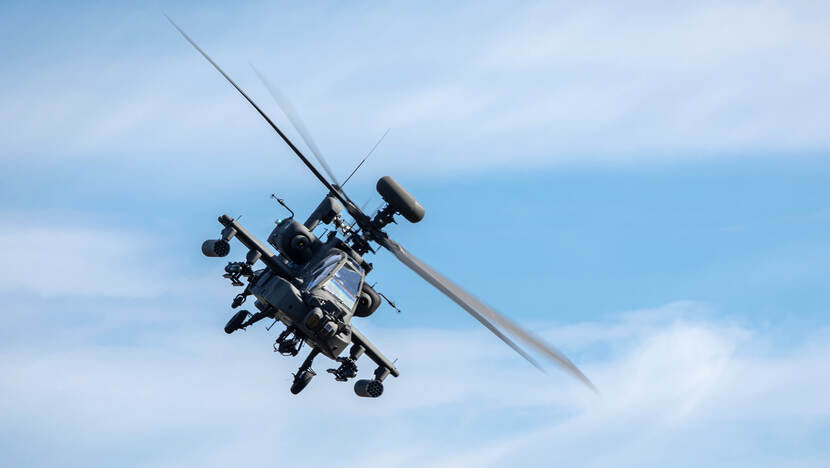 Een AH-64E Apache Echo vliegt voorbij.