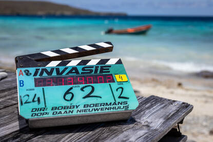 Een blauwe filmklapper op de set met groot het woord ‘Invasie’.