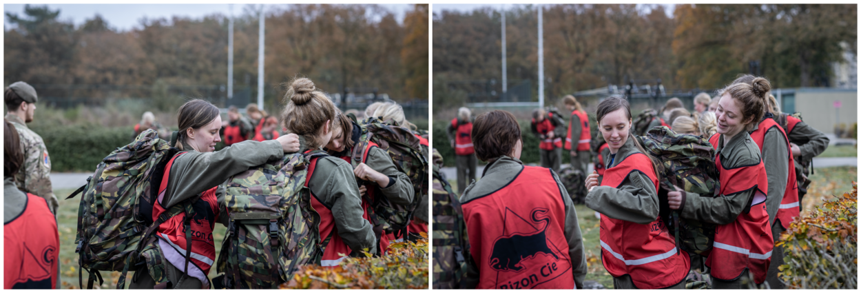 Fotoduo van jonge meiden die een kijkje nemen bij Defensie. Ze helpen elkaar een loodzware rugzak om te hangen.