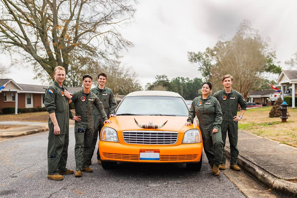 On either side of the orange limousine were five aspiring pilots, four young men and a young woman.