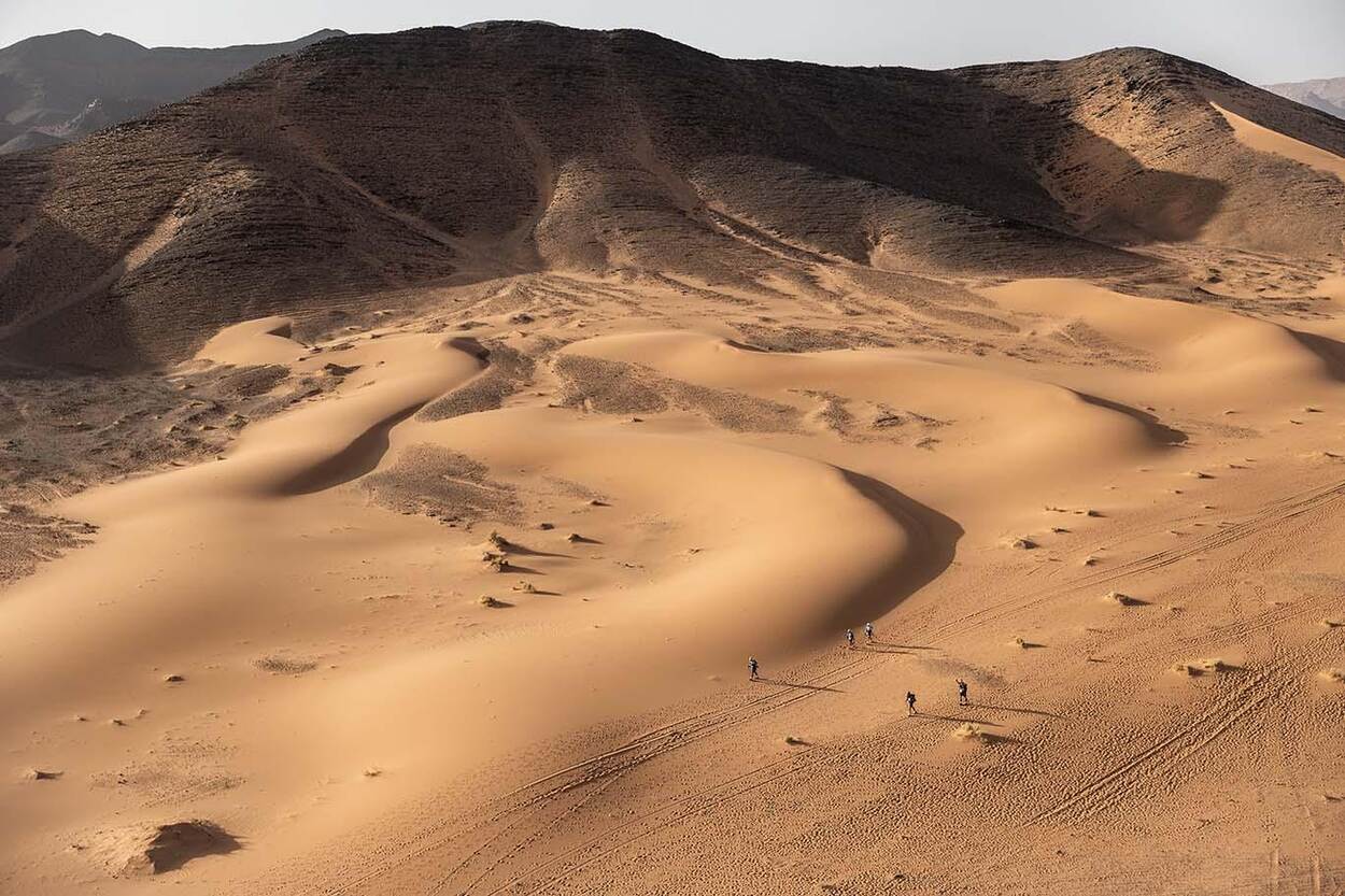 De Sahara met prachtig beige zand, op de achtergrond een berg.