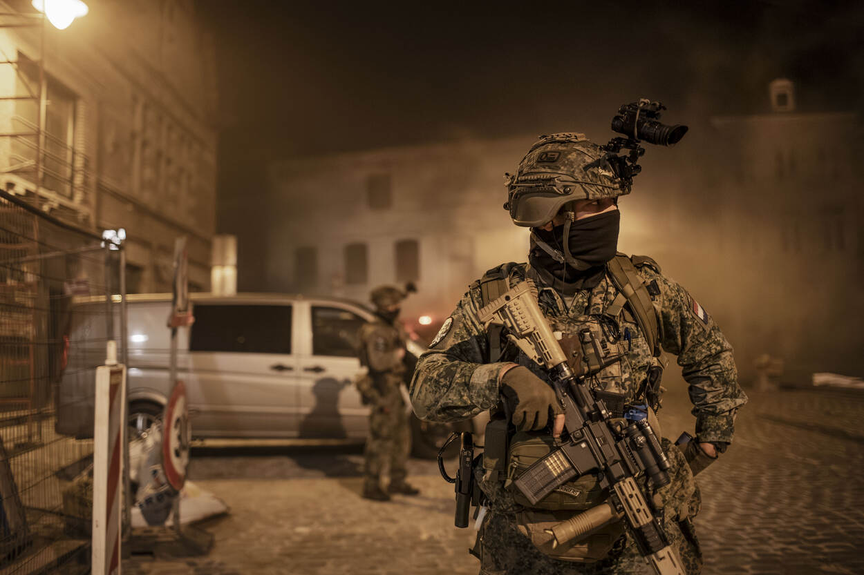 Een bewapende marinier houdt de donkere, stadse omgeving in de gaten.