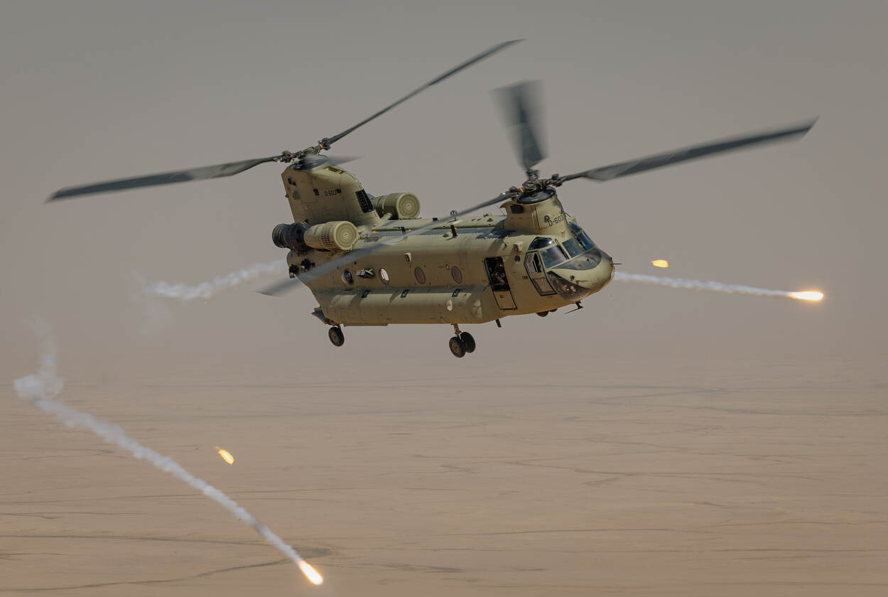 Een Chinook in de lucht boven Irak, met flares om zich heen
