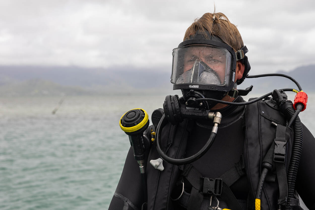 en duiker van het mine countermeasuresteam oefent met een duikmasker op wacht op een bootje tot hij gaat duiken.