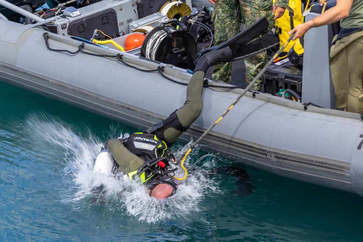 Een duiker van het mine countermeasuresteam oefent procedures in het water.