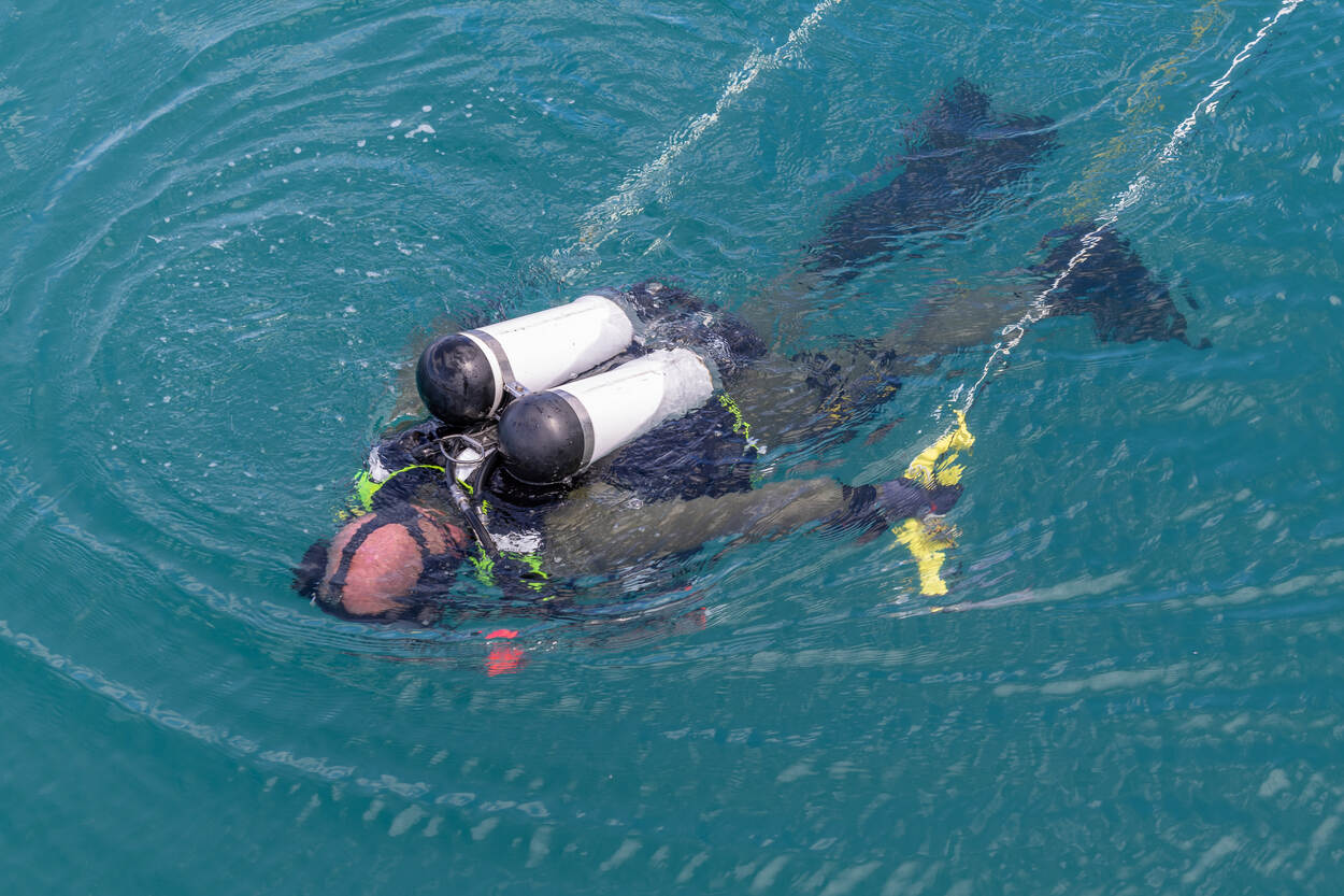 Een duiker van het mine countermeasuresteam oefent procedures in het water.