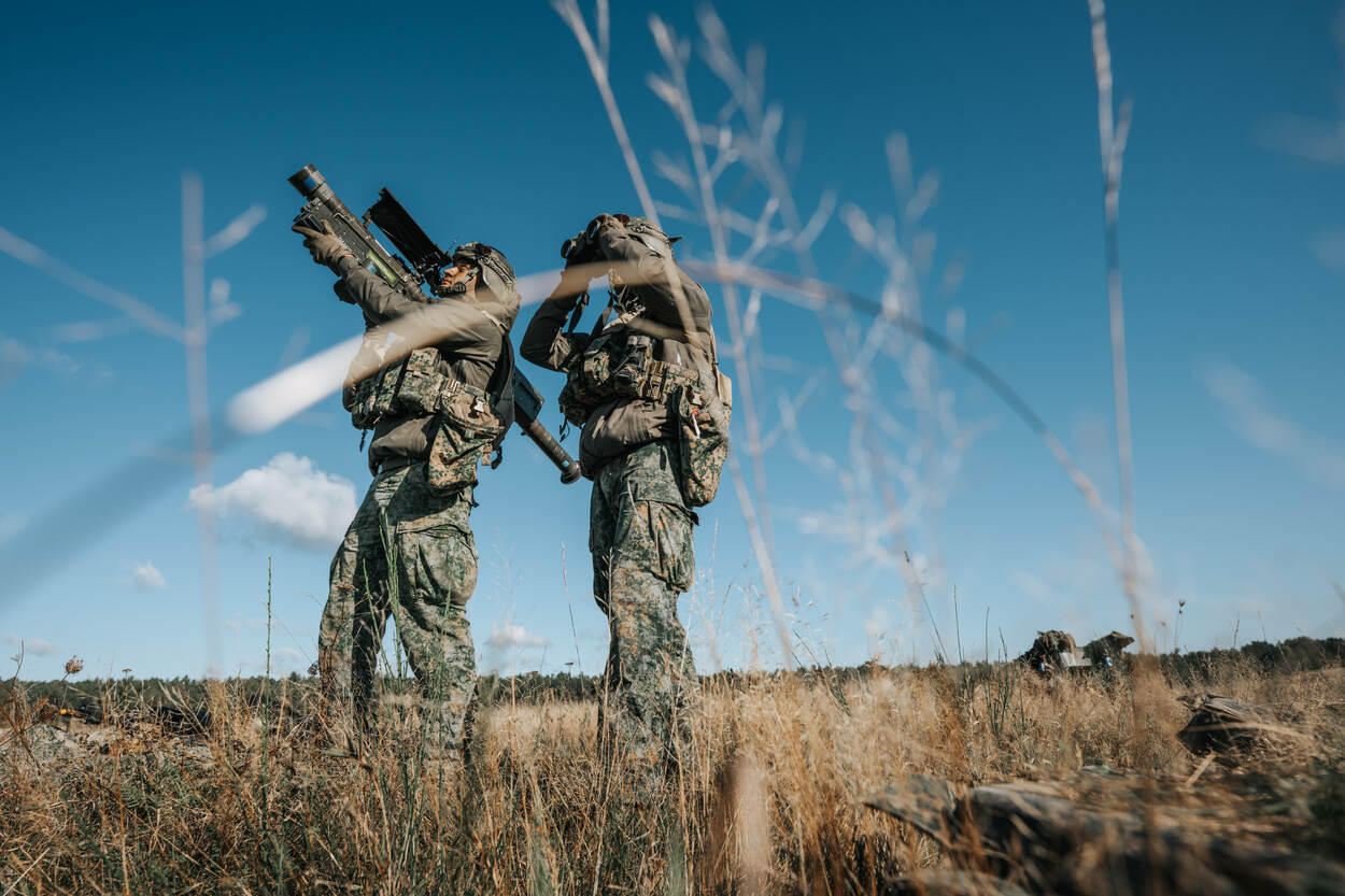 Een militair richt zijn Stinger anti-luchtdoelwapen vanaf de schouder op een naderend vijandelijk vliegtuig.