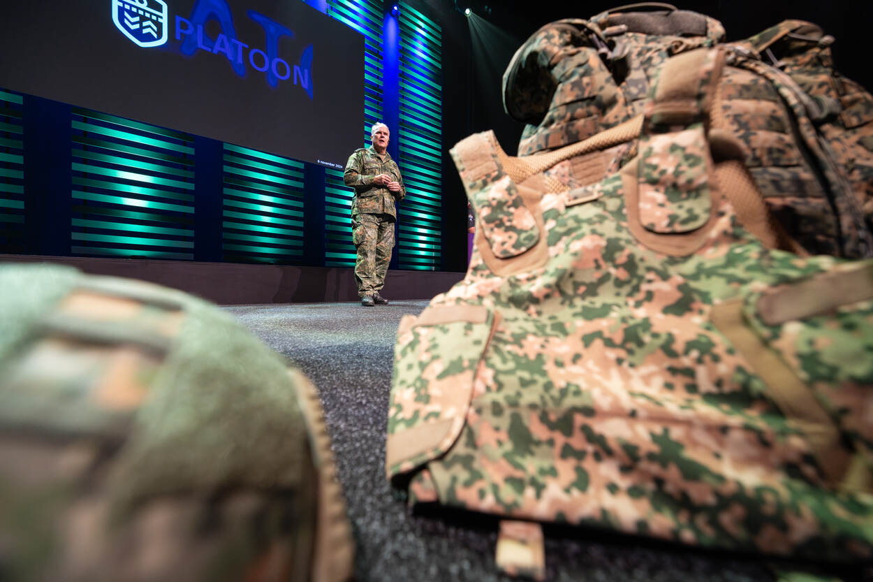 Commandant der Strijdkrachten generaal Onno Eichelsheim op het podium, bezien van achter een OPS-vest met camouflage.