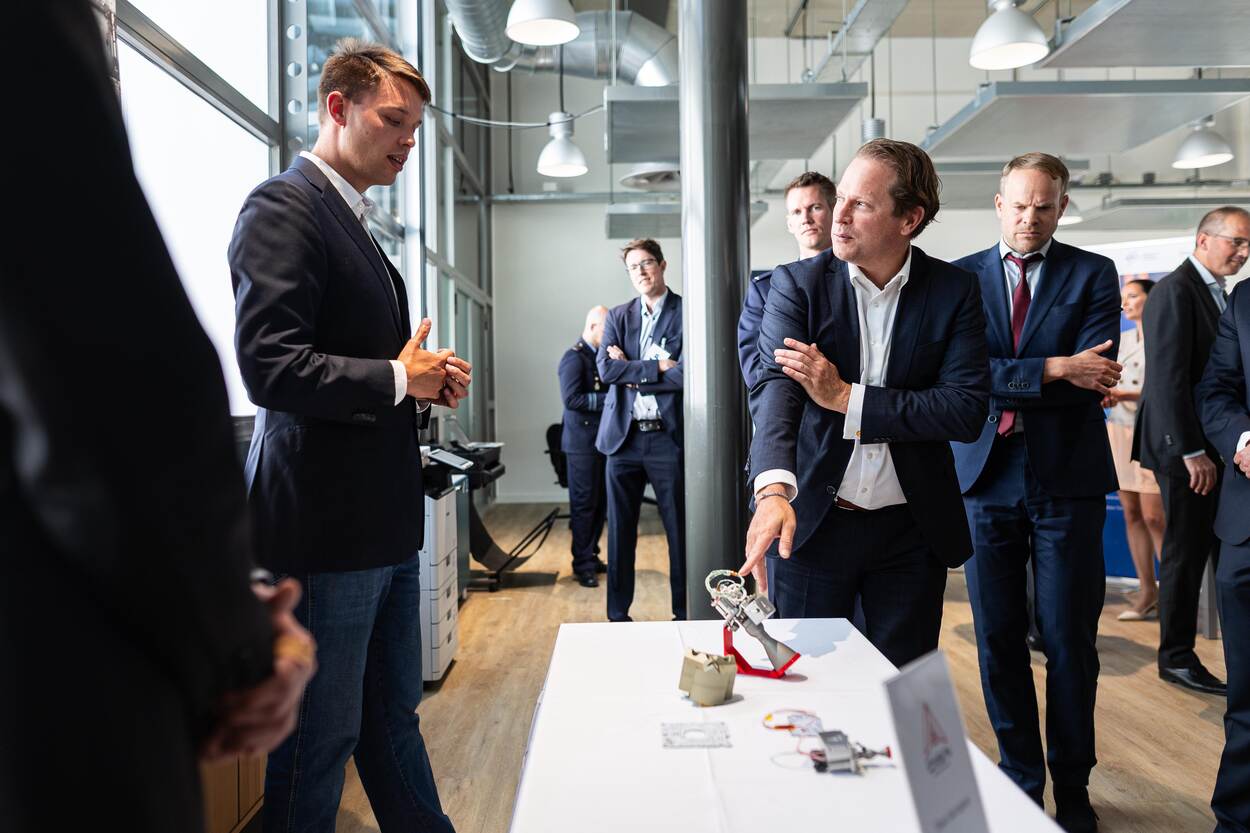 De staatssecretaris krijgt uitleg over een voorwerp.