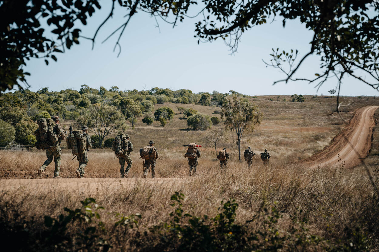 Mariniers lopen achter elkaar in de Australische bush tijdens een oefening.