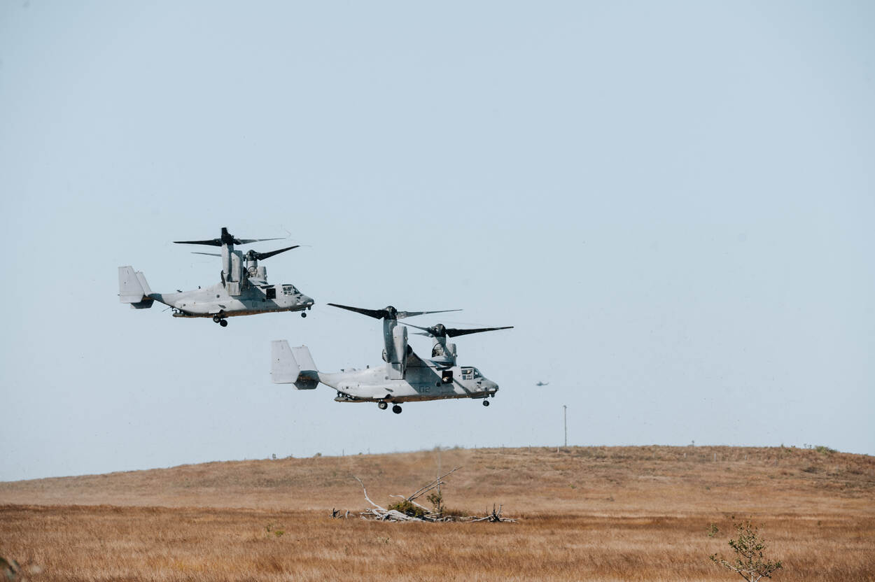 Twee Amerikaanse Osprey-toestellen hangen boven de grond.