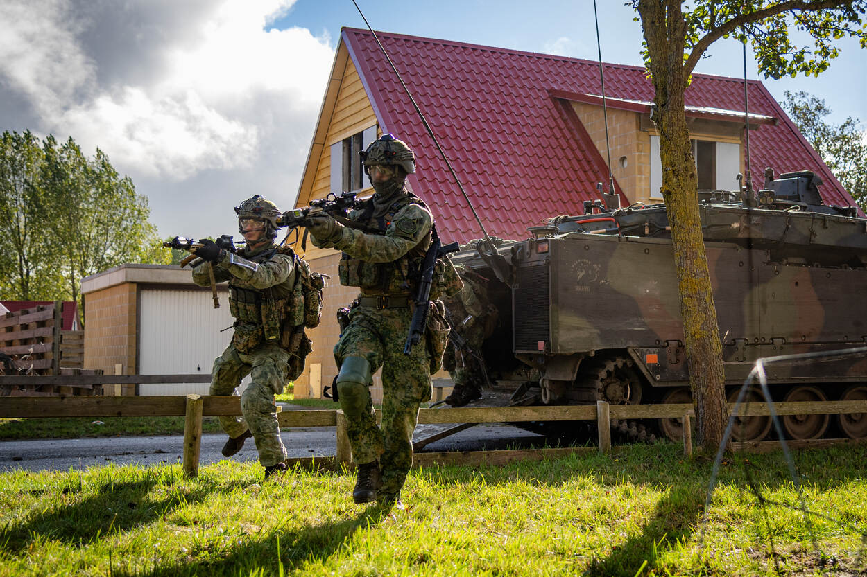 Militairen van 45 Pantserinfanteriebataljon rennen naar een pand in oefendorp Marnehuizen.