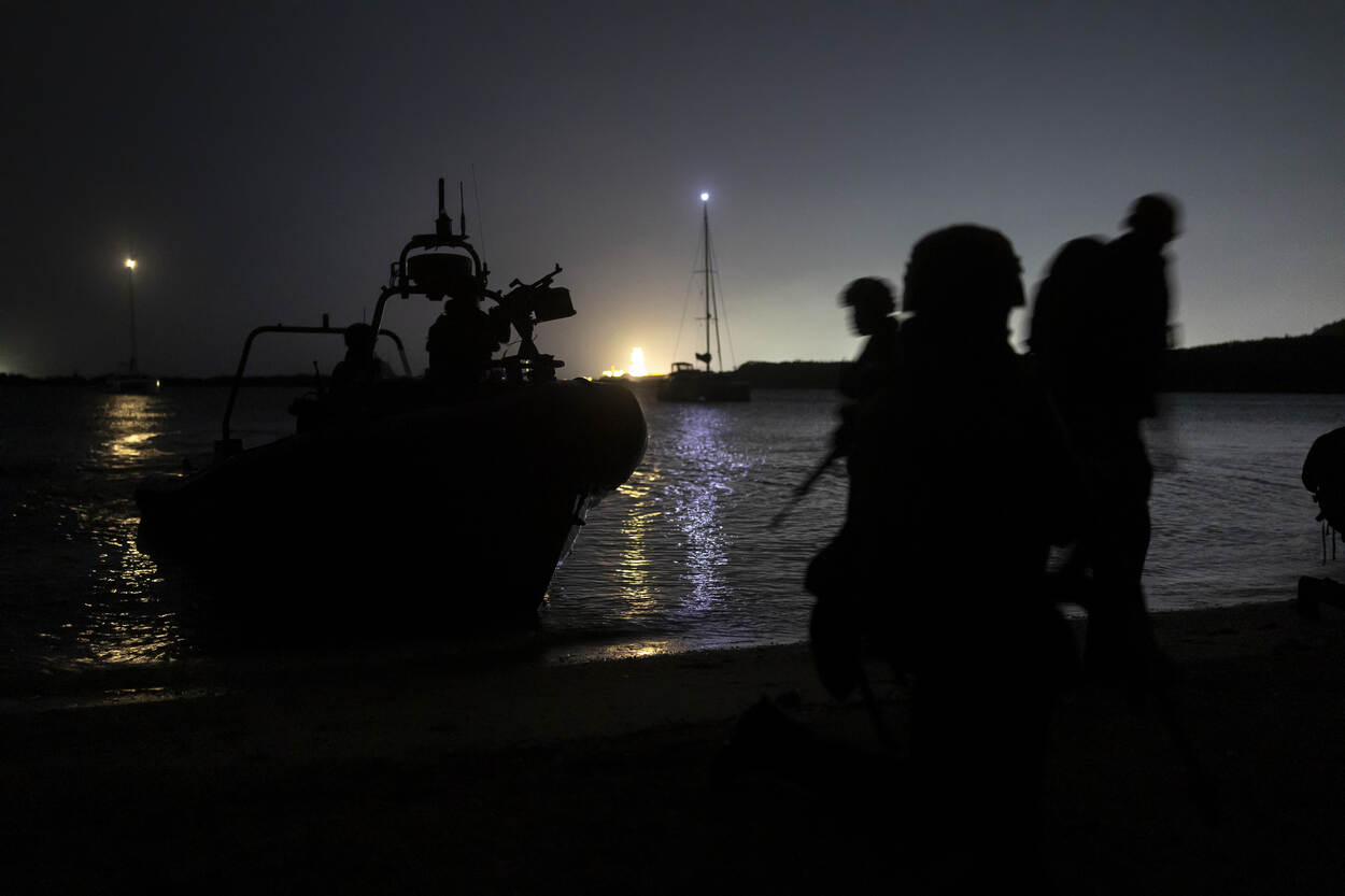 Militairen stappen uit de FRISC op het strand in het donker.