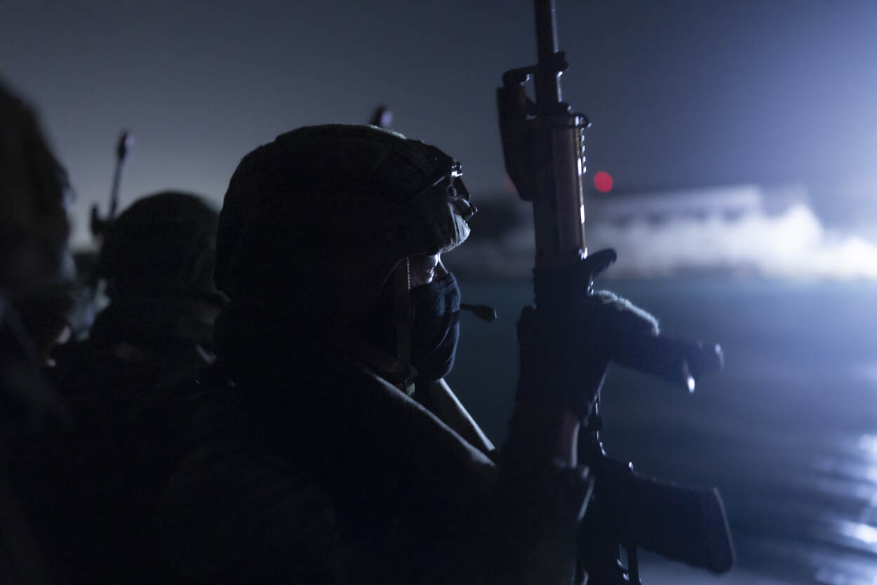 Een militair op een FRISC houdt zijn wapen vast