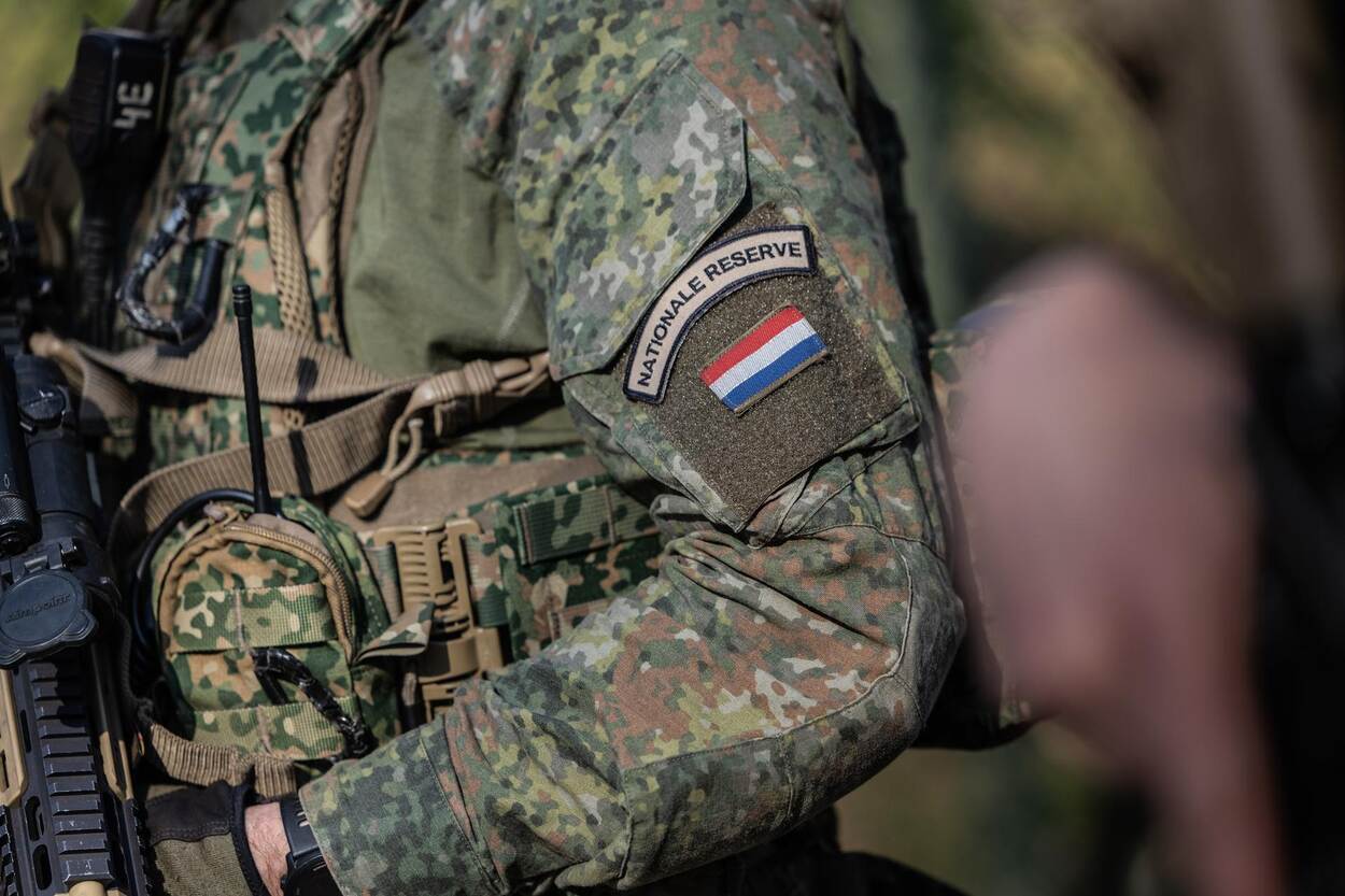 Een bewapende militair met het logo van een eenheid op de mouw.