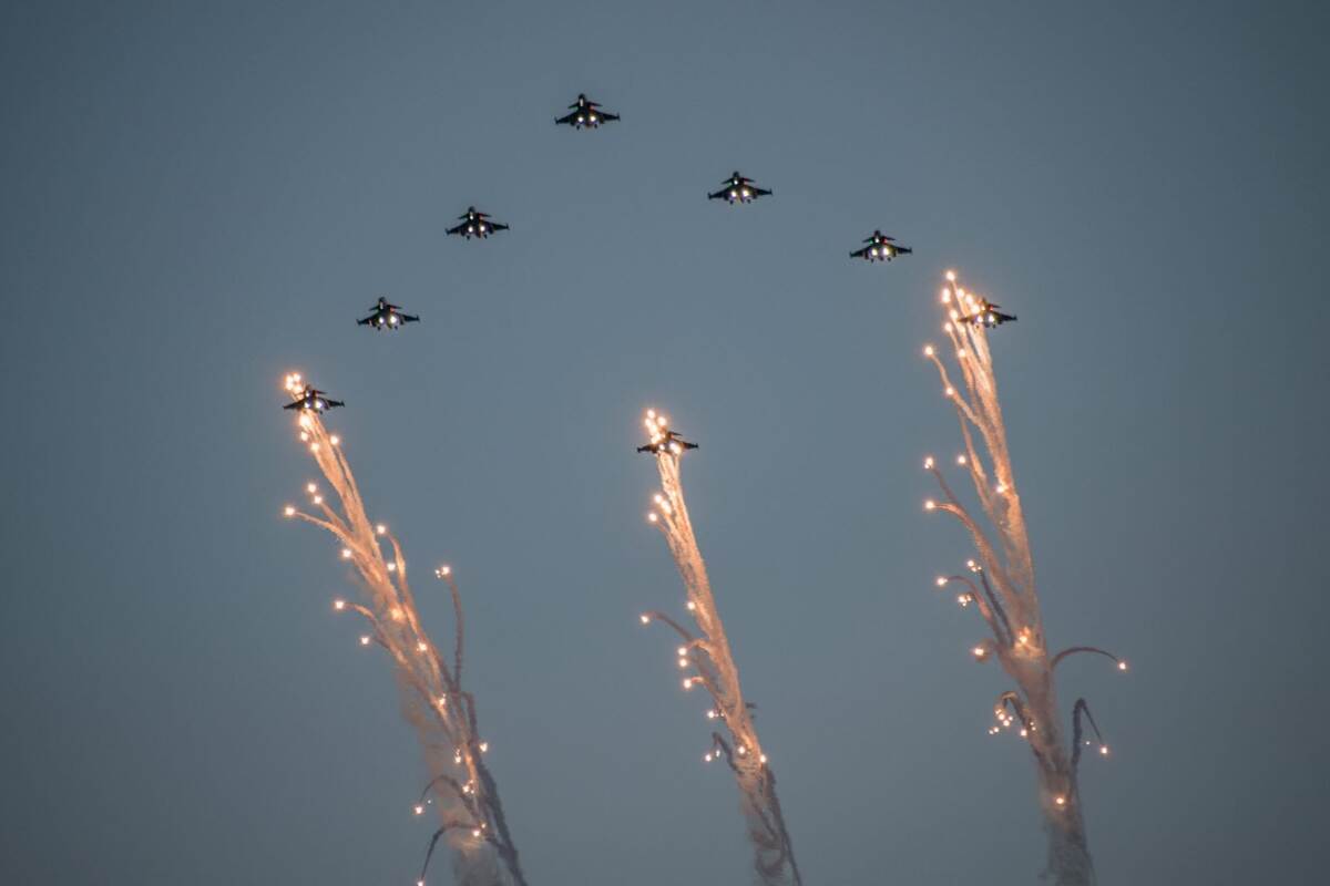 8 straaljager vliegen in formatie met daaronder 3 kerstbomen.