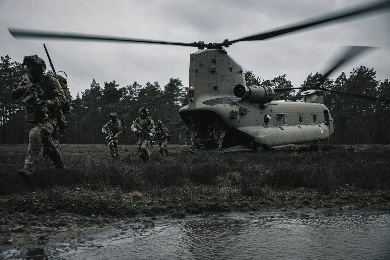 Militairen lopen weg van een helikopter.