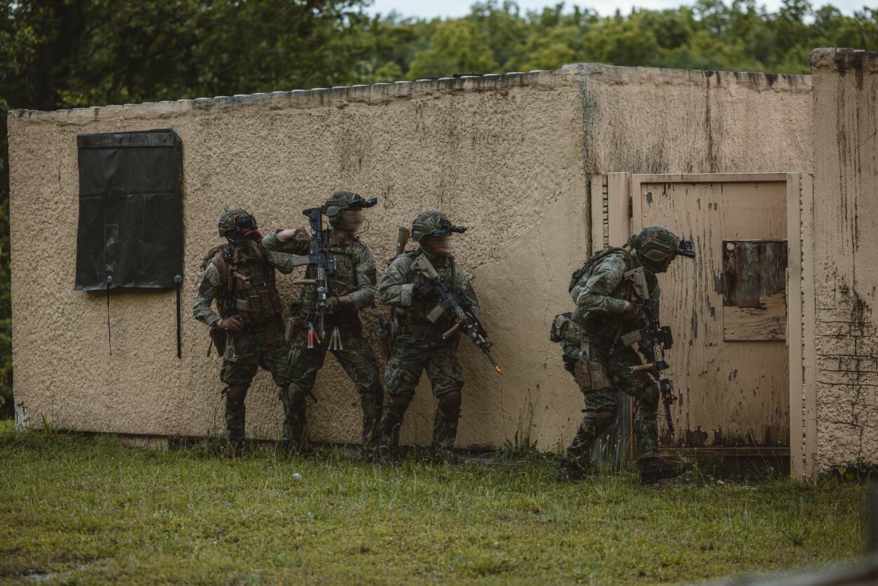 een groep soldaten staat naast een gebouw