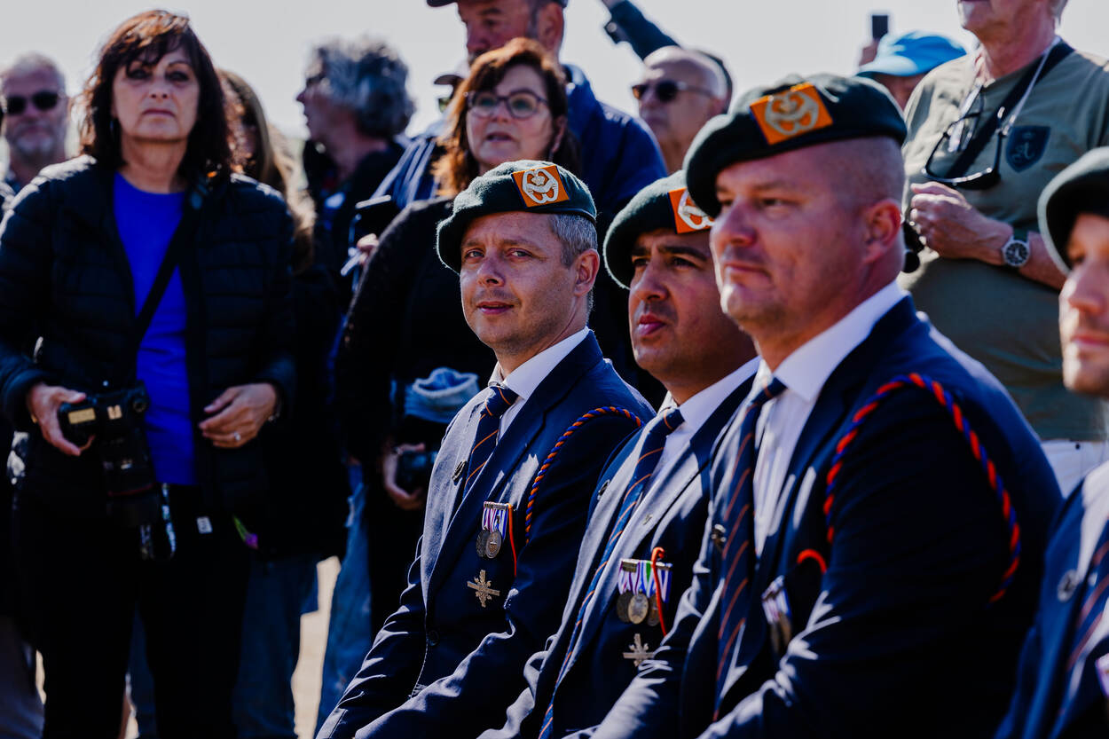 Drie DIG-dragers in hun donkerblauwe uniform naast elkaar.
