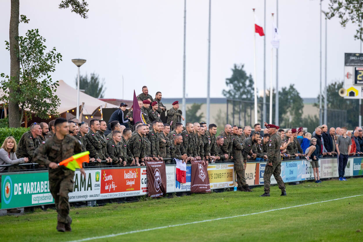 Militairen langs de kant van het veld