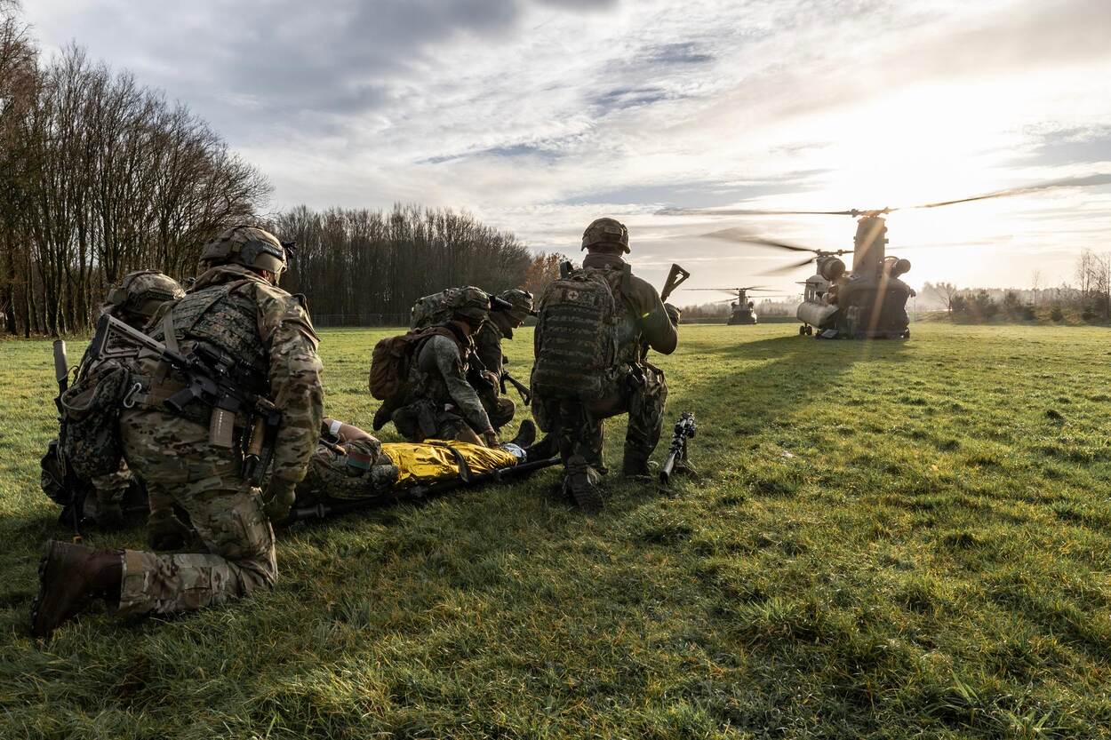 Militairen naast een helikopter.