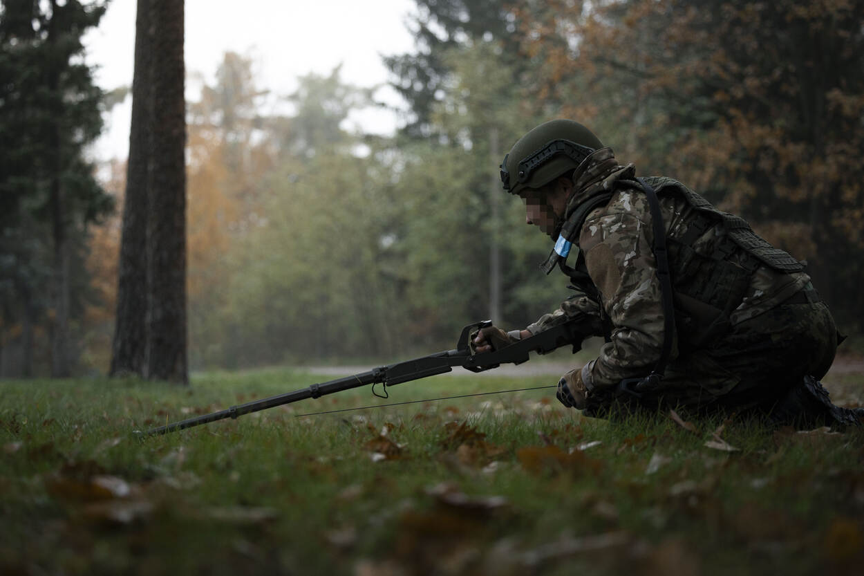 Een Oekraïense militair zoekt naar mijnen.