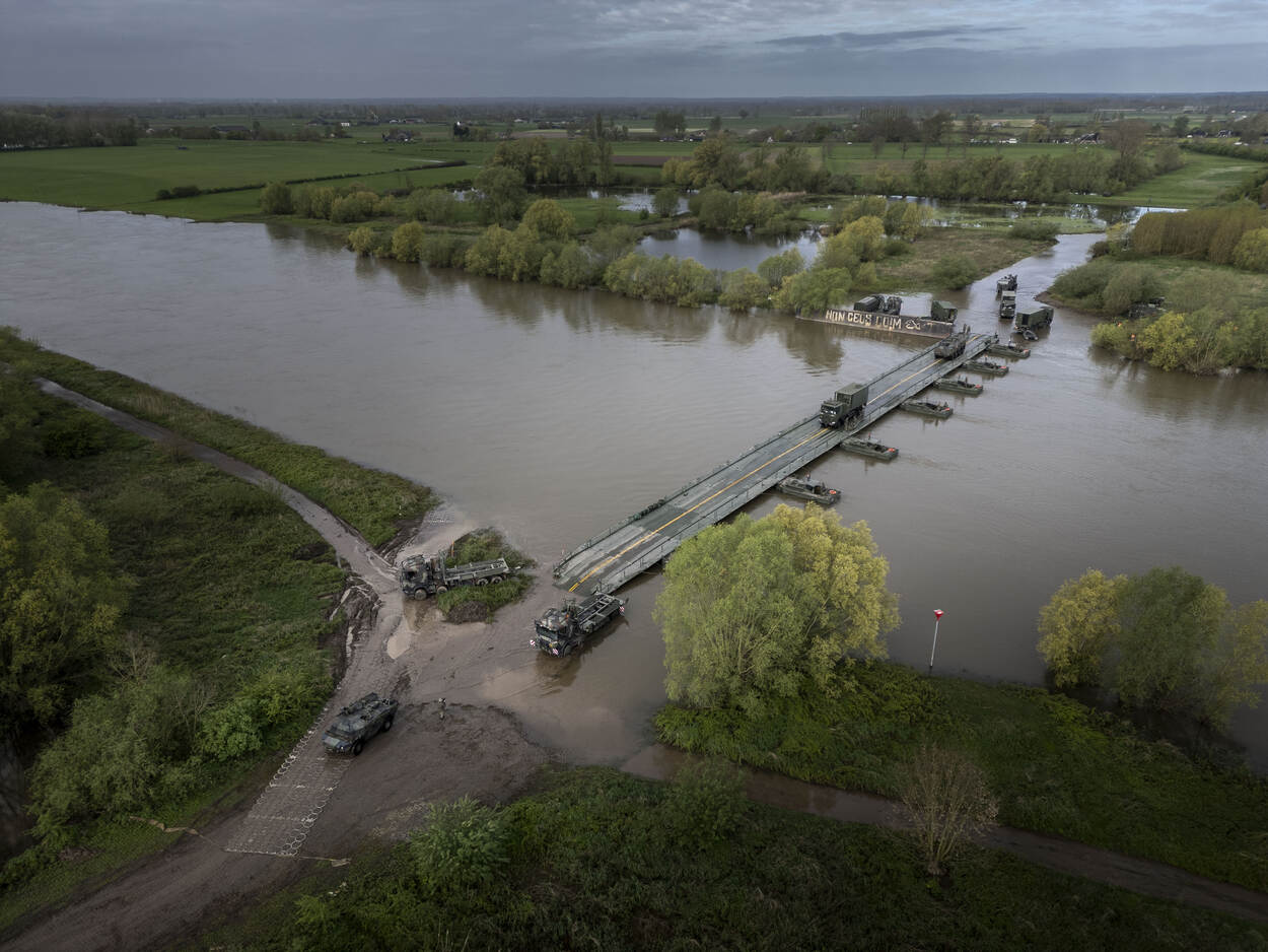 Militairen steken een brug over.