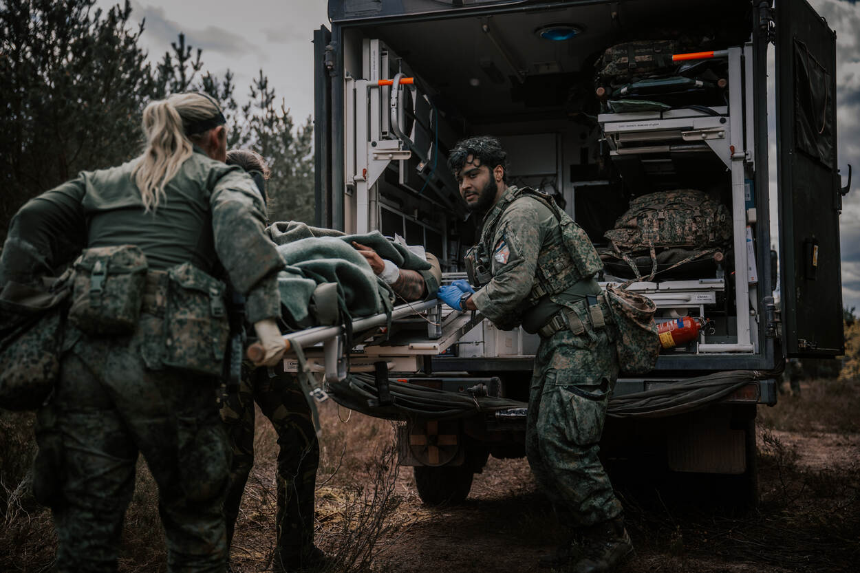 Medisch militair personeel is druk met een oefenslachtoffer.