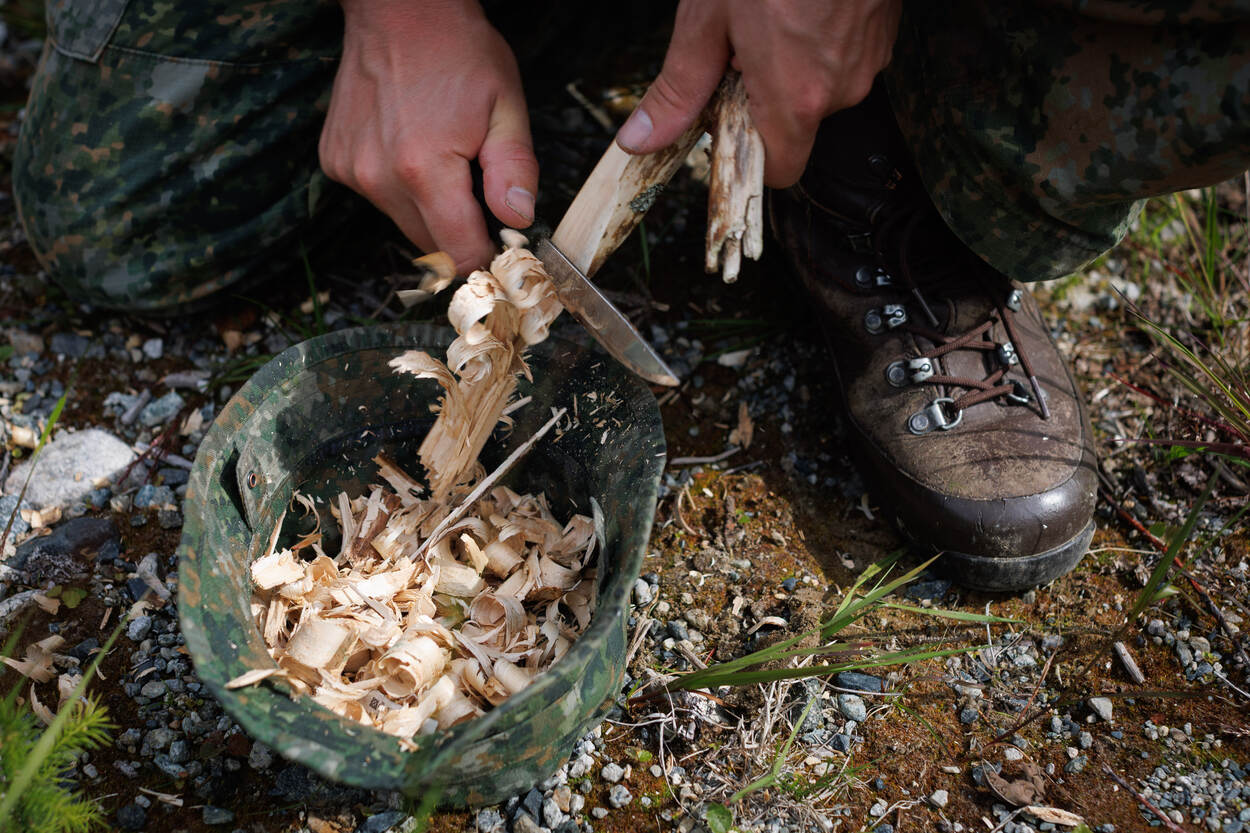 Militair verzamelt houtsnippers.