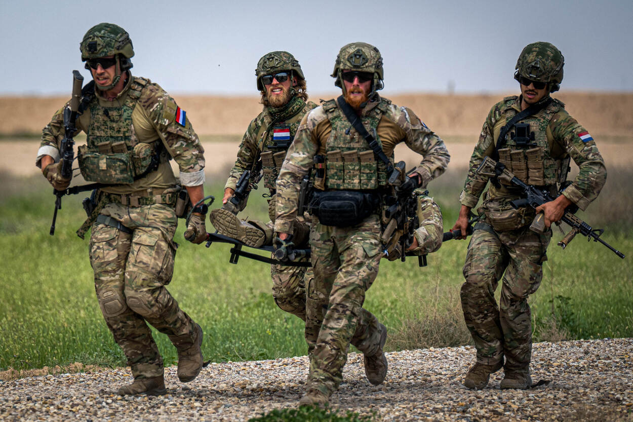 Militairen van 11 Luchtmobiele Brigade tillen tijdens een oefening in Irak een gewonde militair.