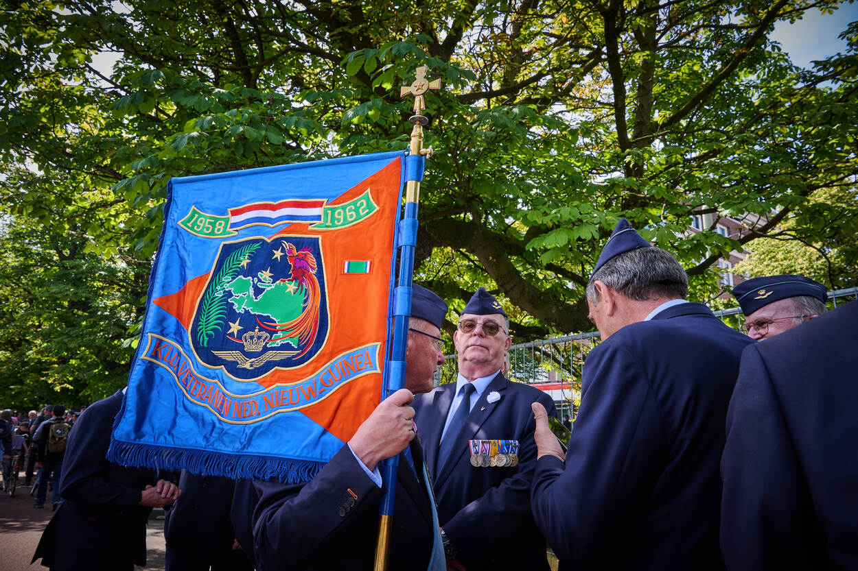 Luchtmachtveteranen staan klaar met een vlag van de Nederlands Nieuw-Guinea-veteranen.