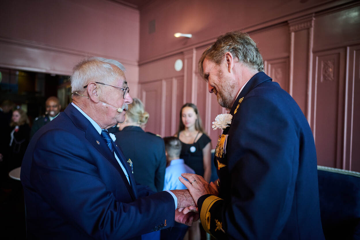 Veteraan Hans van Leest (links) spreekt met koning Willem-Alexander.