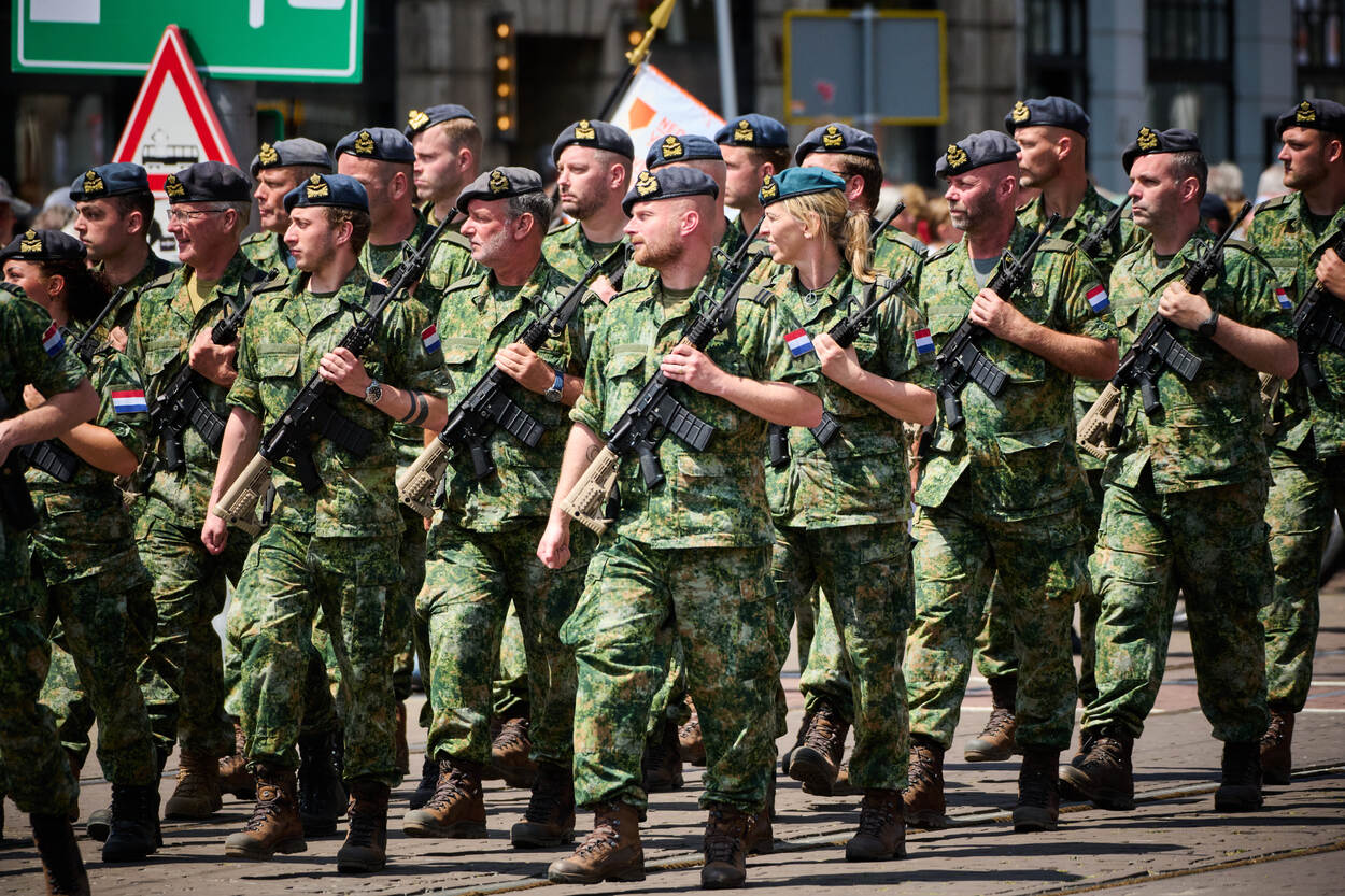 Een groep luchtmachtmilitairen in groen gevechtstenue met geweer op de borst marcheert voorbij.