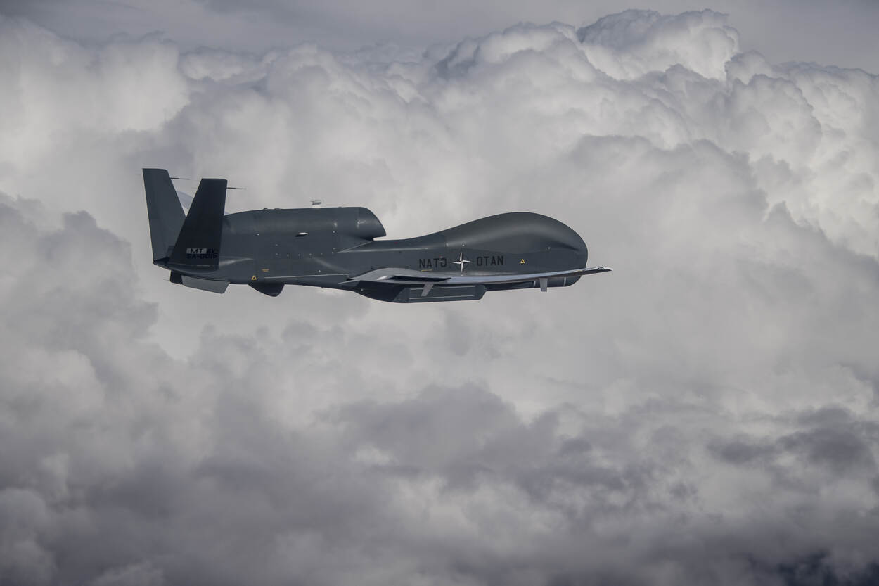 Een RQ-4 vliegt boven een imposant wolkendek.