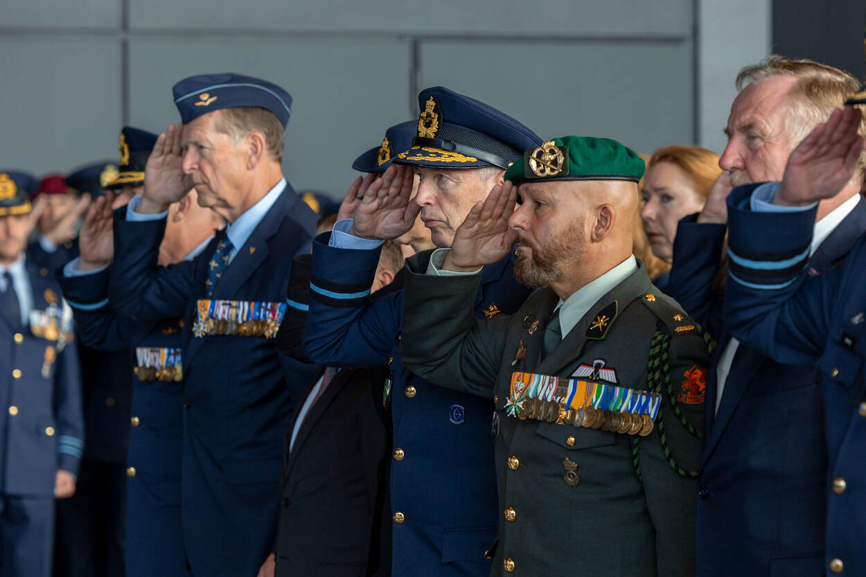 Actieve en postactieve generaals en commodores salueren terwijl buiten het beeld van de camera een kranslegging wordt gedaan. Onder hen ook Ridder Militaire Willems-Orde Marco Kroon.