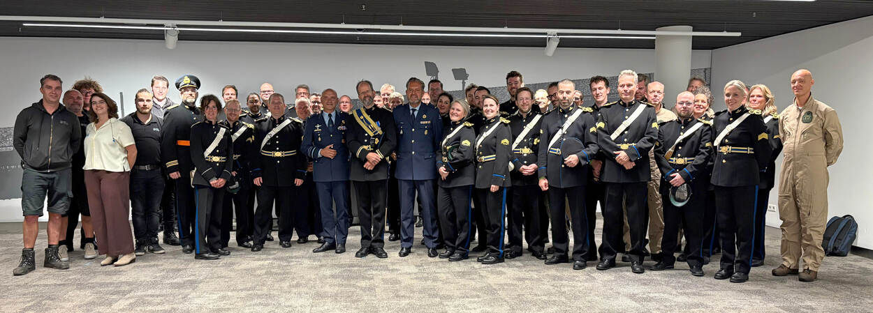 Pijnenborg poseert te midden van de leden van het Orkest Koninklijke Luchtmacht.