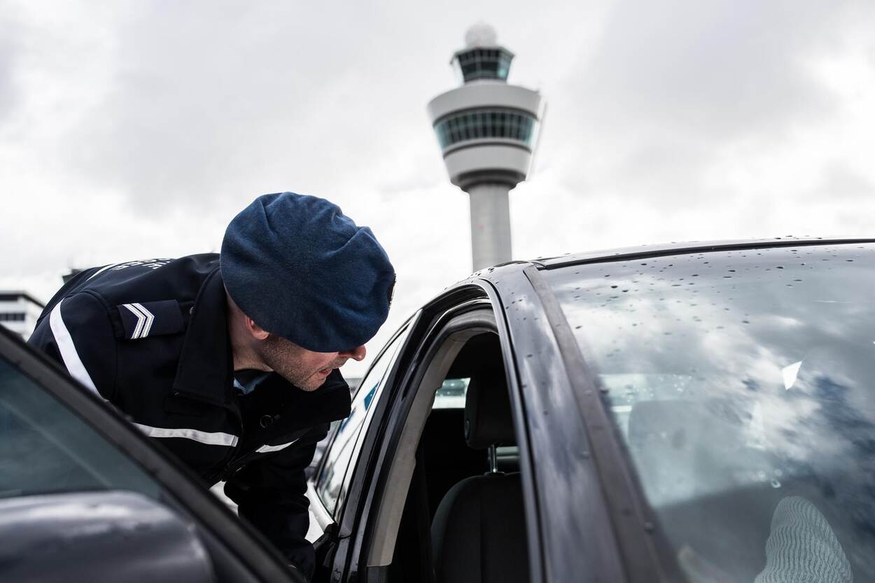 Een marechausseecollega controleert een voertuig.