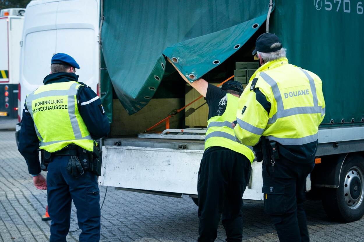 Collega's doorzoeken de laadruimte van een vrachtwagen.