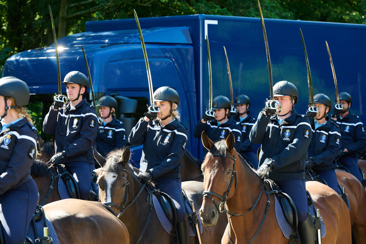 Marechaussees te paard salueren met hun sabel