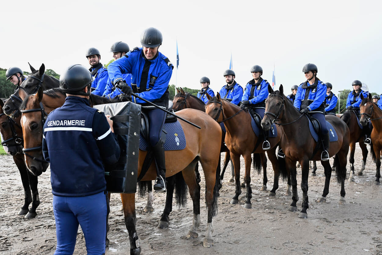 Op een modderige renbaan, slaat een Marechaussee in op een stootkussen