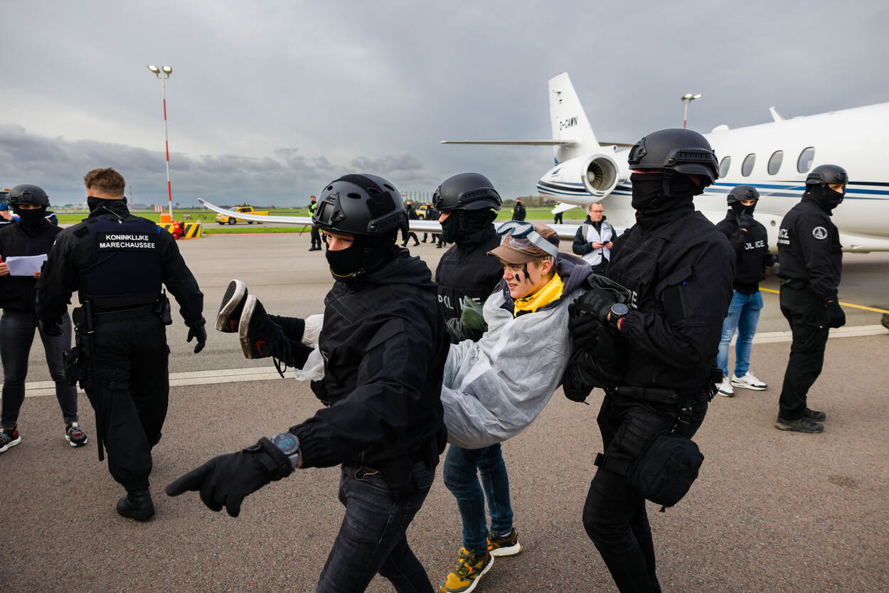 Demonstranten van Greenpeace en Extinction Rebellion op Schiphol.