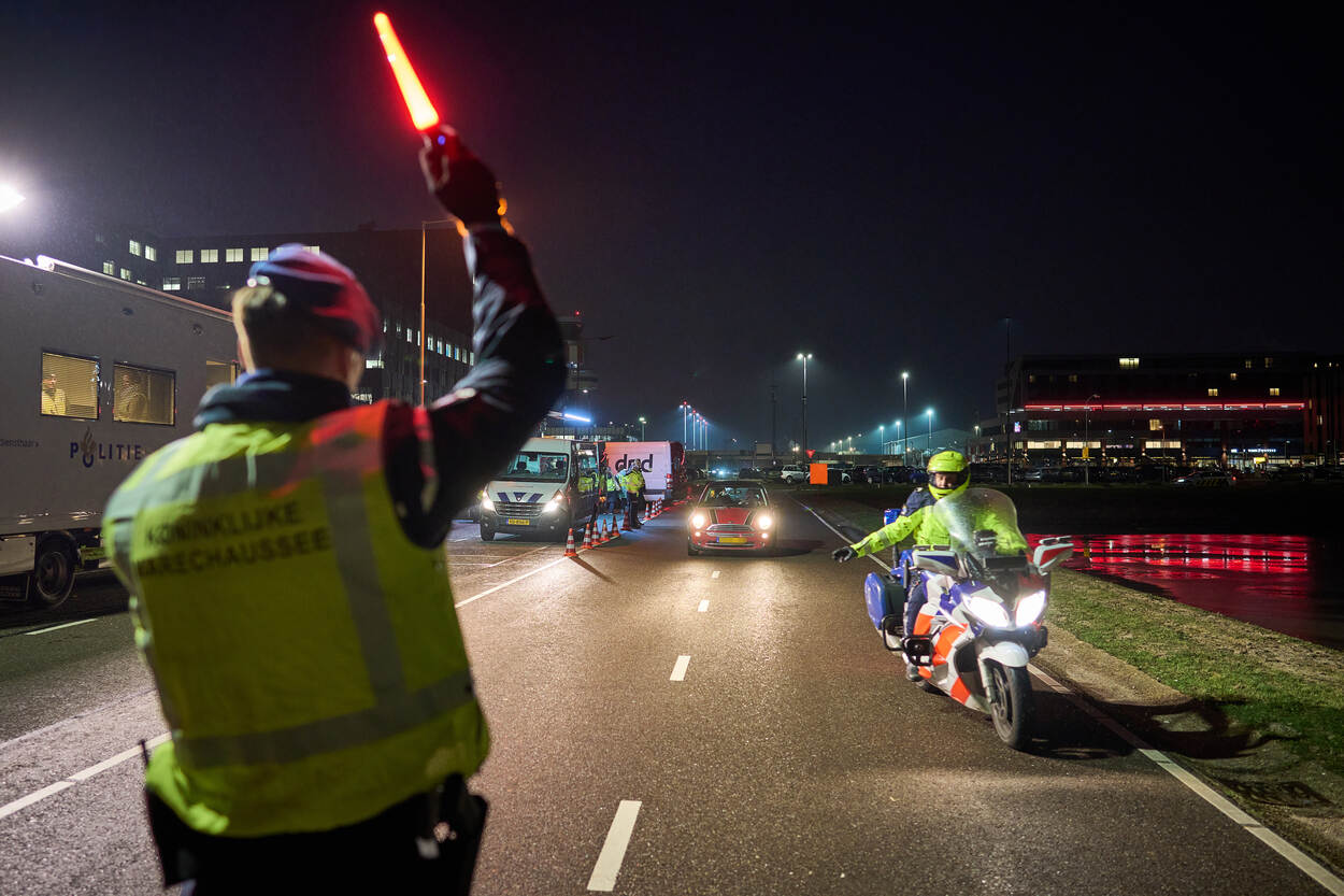 Marechaussee-collega’s seinen een auto naar de vluchtstrook.