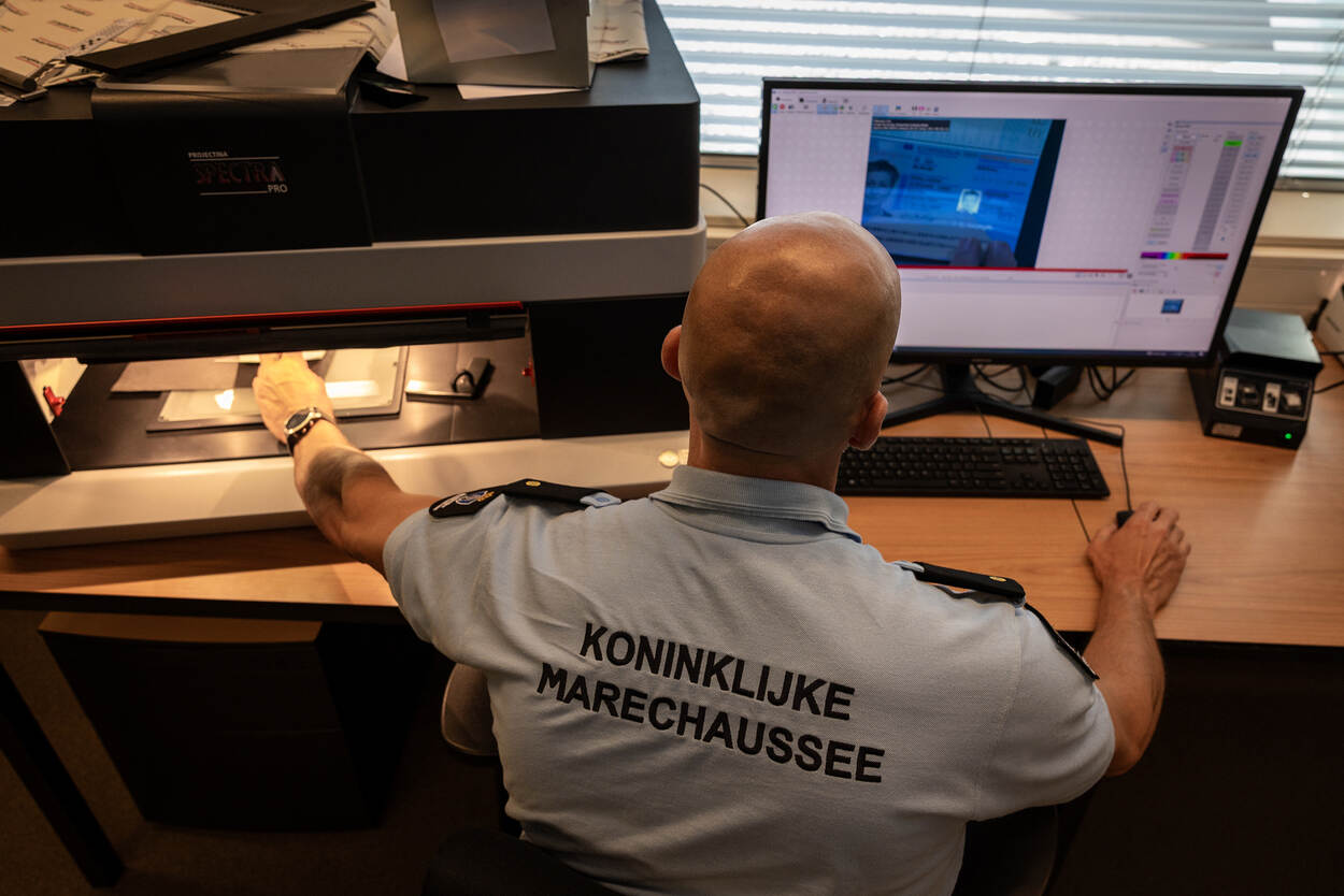 Documentdeskundige Adjudant Raijmond werkt achter zijn computer in de onderzoeksruimte.