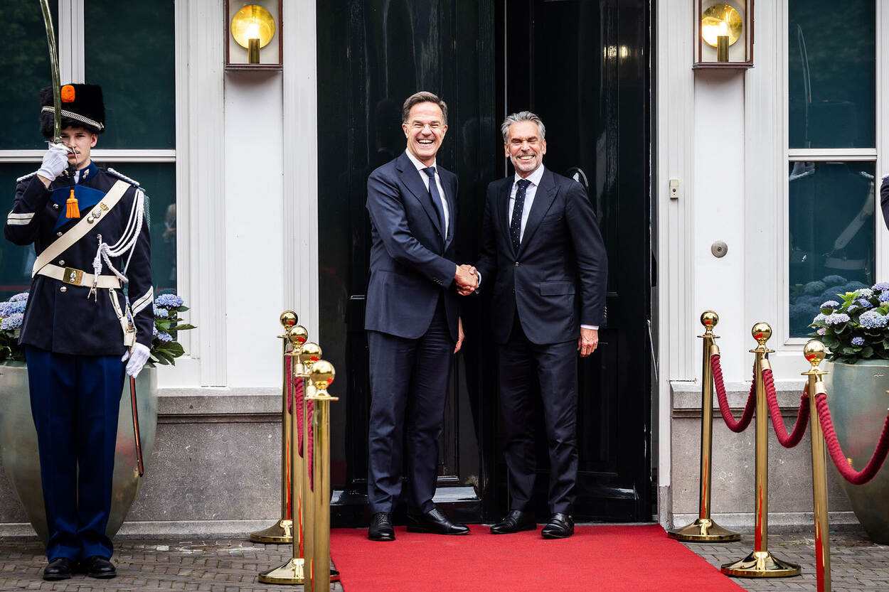Secretaris-generaal Rutte van de NAVO en demissionair premier Schoof van Nederland, schudden elkaar de hand voor het Catshuis, geflankeerd door twee marechaussees.