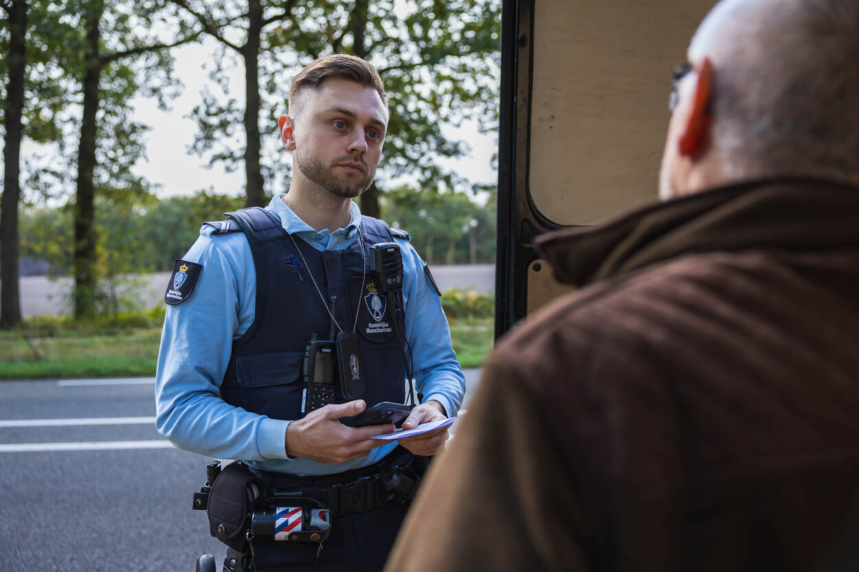 Marechausse in gesprek met een man.