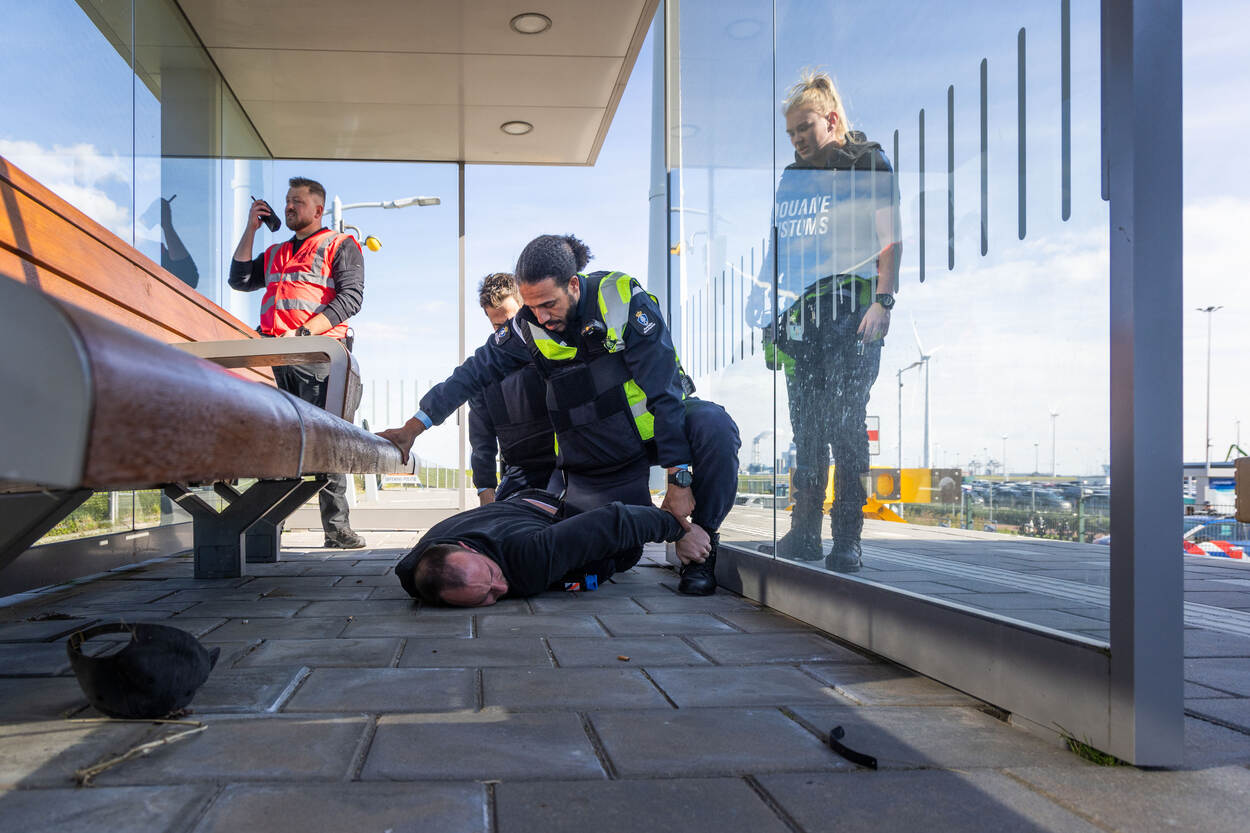 Op treinstation Eemshaven houden marechaussees een verdachte in bedwang.
