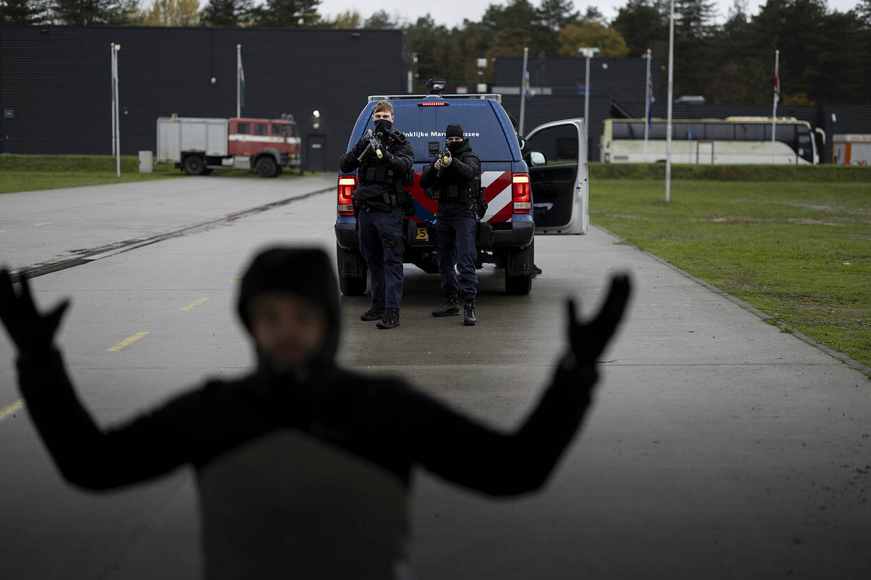 Een verdachte wordt door 3 marechaussees onder schot gehouden.